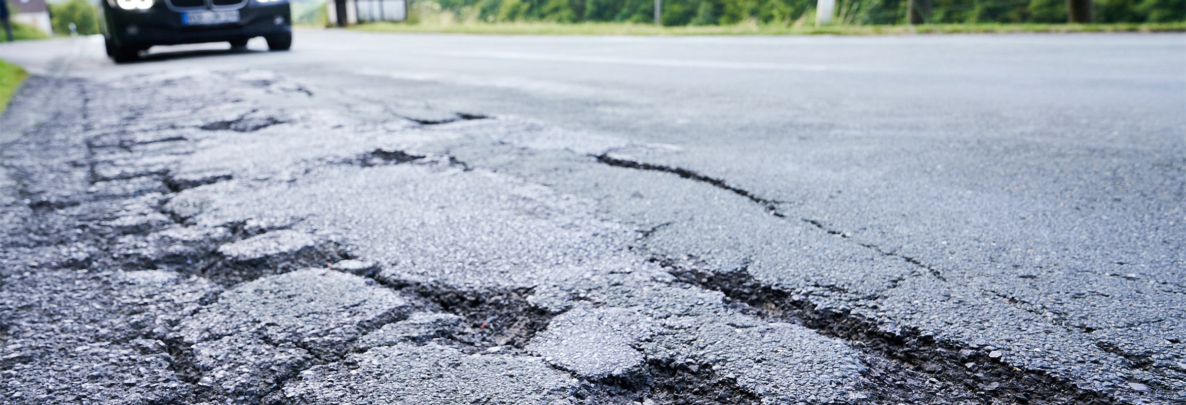 Landesstraße mit beschädigter Fahrbahndecke