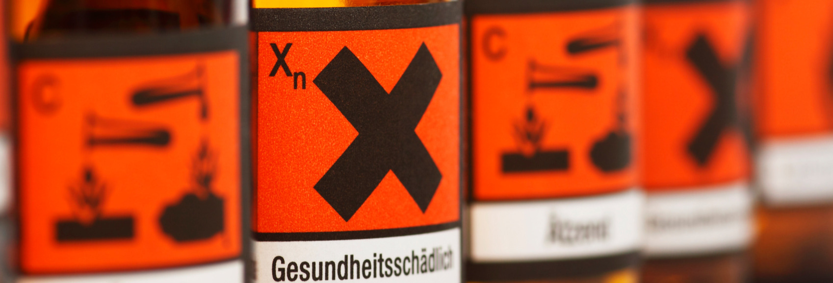 Das Bild zeigt Flaschen mit Gefahrstoff-Symbolen.